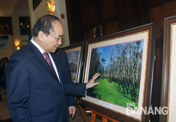 Phó Thủ tướng Nguyễn Xuân Phúc xem triển lãm ảnh về đất nước, con người và phong cảnh Việt Nam sau buổi lễ khai mạc.