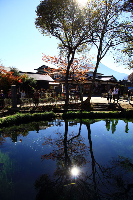 Từ đầu làng, du khách lặng mình trước cảnh đẹp như tranh vẽ của hồ nước nhỏ trong vắt in bóng cây cùng ánh mặt trời và xa xa là bóng núi Phú Sĩ hùng vĩ.