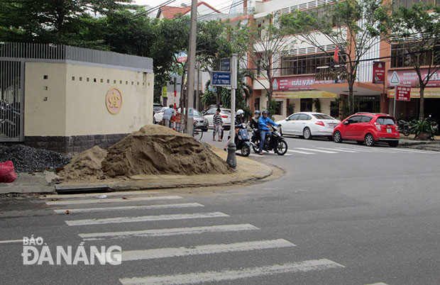 Vỉa hè giao lộ Lý Tự Trọng - Nguyễn Thị Minh Khai bị đống vật liệu xây dựng  chiếm hết.