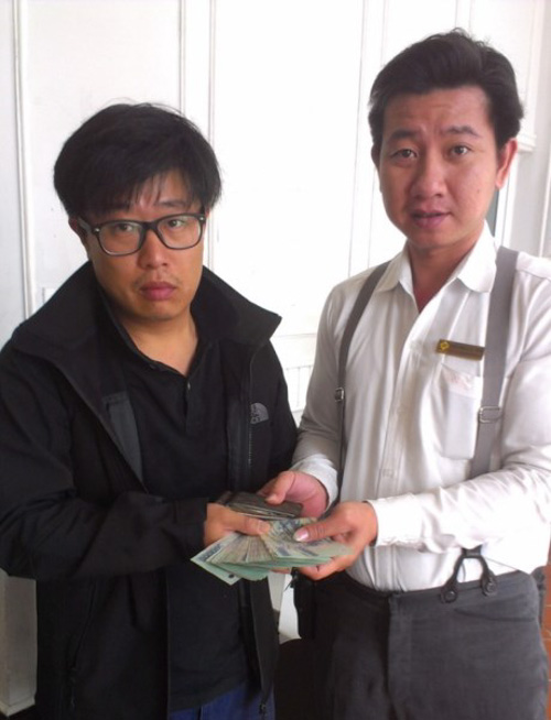 Mr Tam (right) returning the money to the Korean visitor