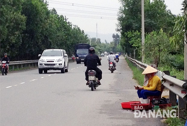 Buôn bán trên quốc lộ 14B rất nguy hiểm nhưng người dân vẫn “bám” đường. 