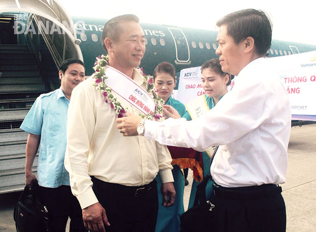 Đại diện Cảng hàng không quốc tế Việt Nam tặng hoa cho hành khách thứ 6 triệu thông qua Cảng. Ảnh: HOÀNG HÂN
