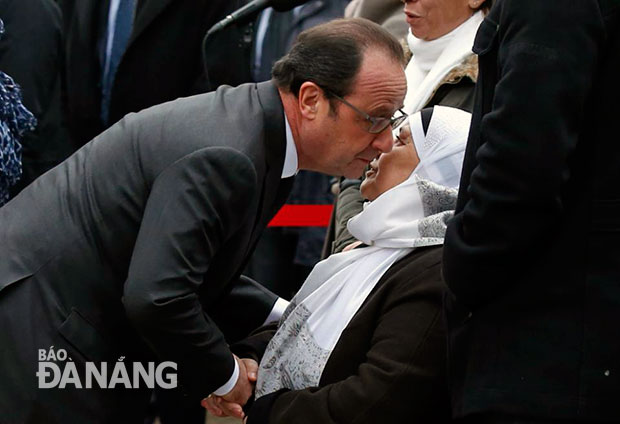 Tổng thống Pháp Francois Hollande chia sẻ với thân nhân của một nạn nhân thiệt mạng trong vụ tấn công ở Charlie Hebdo.  Ảnh: AP