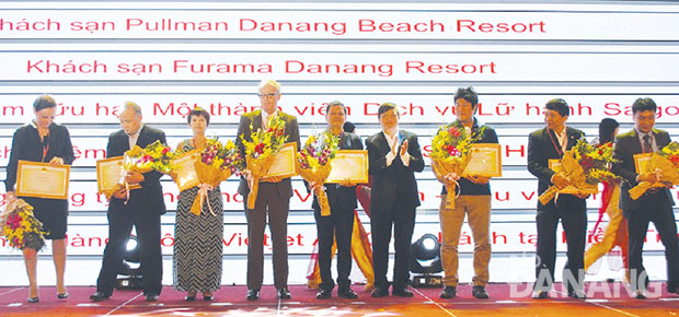 Phó Chủ tịch UBND thành phố Đặng Việt Dũng tặng bằng khen cho các doanh nghiệp đóng góp lớn cho ngành du lịch thành phố trong năm 2015.  ảnh: Thu Hà
