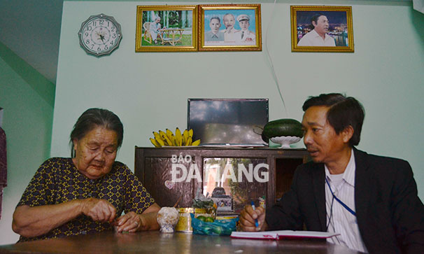 Mẹ Việt Nam anh hùng Phùng Thị Thúy kể chuyện xưa cho cán bộ địa phương nghe trong căn nhà vừa được hỗ trợ sửa chữa khang trang.
