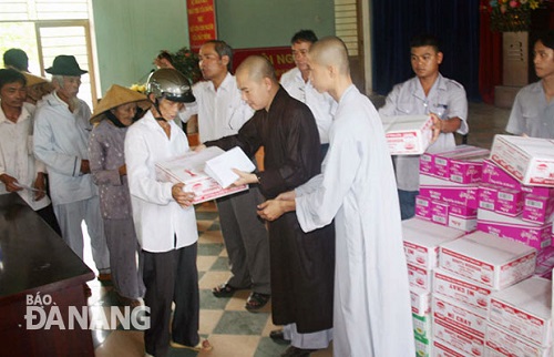 Representatives from the pagoda presenting gifts to poor people