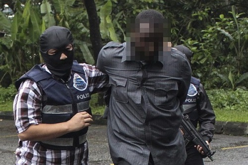 Malaysian police arrest a suspect.