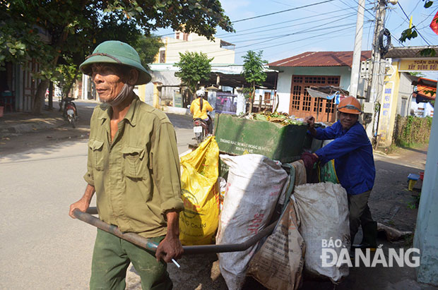 Ông Nguyễn Đình Thành (người kéo xe) và ông Nguyễn Văn Chiến đẩy xe đi từng nhà thu gom rác thải.