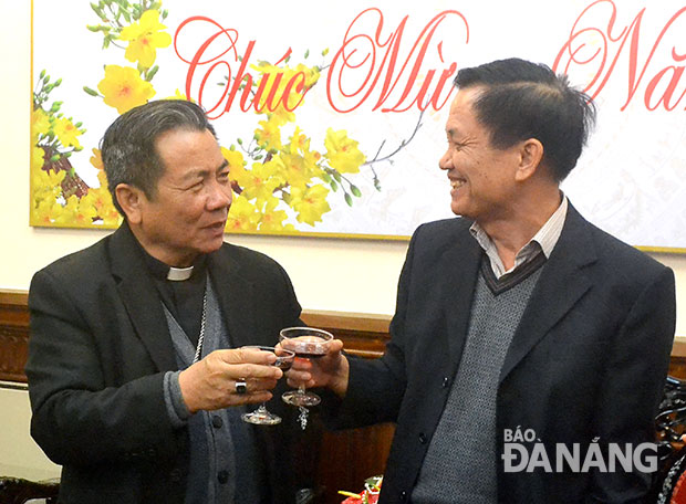 Chủ tịch HĐND thành phố Trần Thọ (phải) và Giám mục Giáo phận Đà Nẵng Châu Ngọc Tri mừng năm mới. 			Ảnh: ĐẶNG NỞ