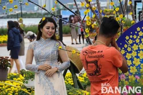 Posing for a photo at a floral decoration along Bach Dang 