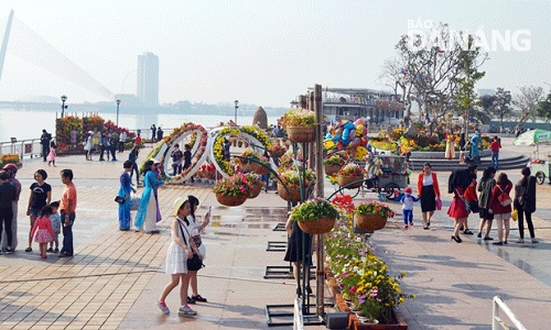    Visitors at the floral displays near the Rong (Dragon) Bridge