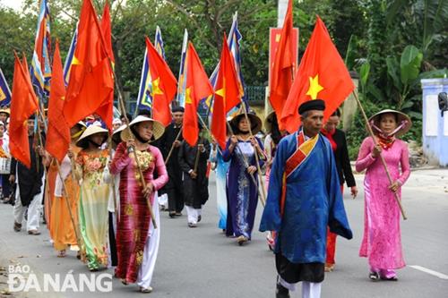 Local women in ao dai carrying national flags