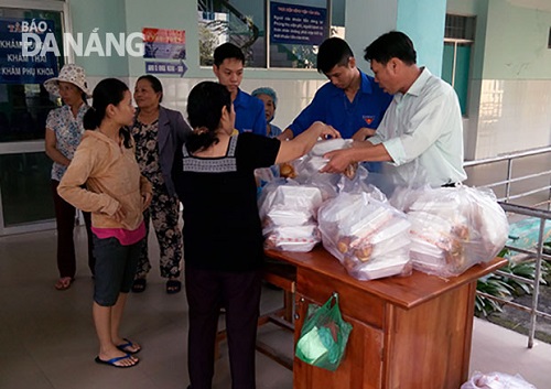 Thang (first right) giving free meals to poor patients in the Lien Chieu District Medical Centre