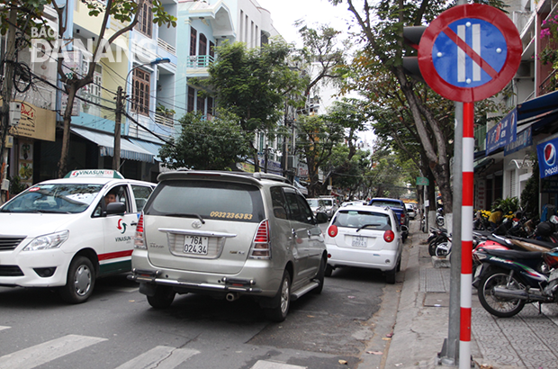 Mặc dù biển báo đã lắp đặt xong vài ngày nhưng nhiều ô-tô con vẫn đậu, đỗ vi phạm cấm đỗ xe ngày chẵn tại đường Trần Quốc Toản vào sáng 24-2 khiến các phương tiện lưu thông khó khăn. 			Ảnh: HOÀNG HIỆP