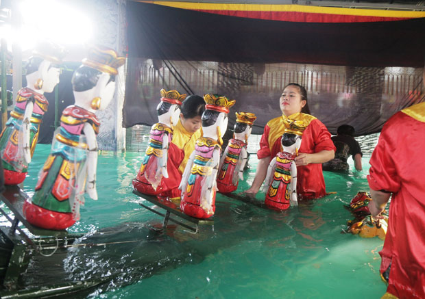 Các nghệ nhân rối nước của Nhà hát tuồng Nguyễn Hiển Dĩnh chuẩn bị đưa con rối ra biểu diễn vở “Lê Lợi khởi nghĩa” hôm mồng 4 Tết tại Công viên 29-3.
