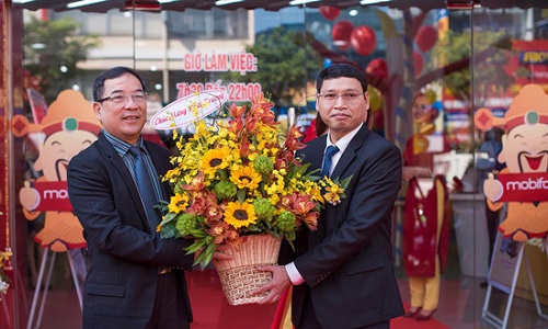 Vice Chairman Ho Ky Minh (right) presenting flowers to a representative from Mobifone Telecom Corporation