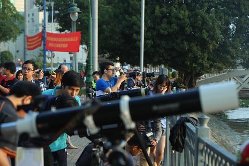 Astronomy and photography enthusiasts gather on the bank of the Saigon River in District 1 to observe and take photos of the partial solar eclipse in Ho Chi Minh City