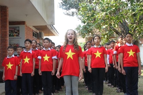 Capri Everitt sings the Vietnamese national anthem with children of the SOS Children’s Village in Da Nang (Source: tuoitre.vn)