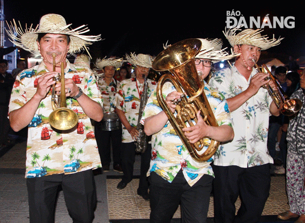 Đoàn nghệ sĩ chơi nhạc cụ kèn hơi và các vũ công bắt đầu tiến ra đường Trần Hưng Đạo.