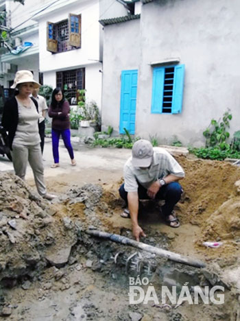 Ông Dương Sa chỉ vị trí mặt bê-tông cống thoát nước liên phường bị bể trong quá trình thi công.