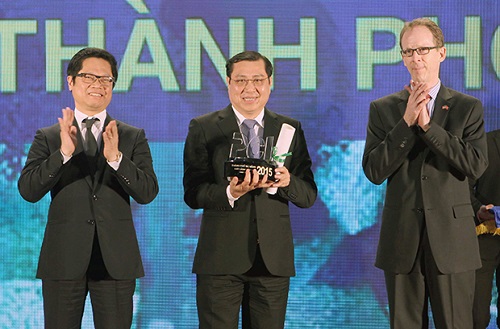 Chairman Tho (middle) receiving the souvenir cup in recognition of Da Nang’s top position in the PCI 2015 on behalf of the local leaders and citizens