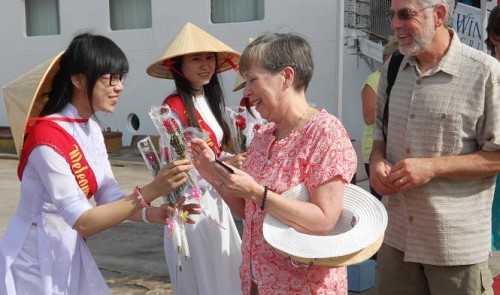 Two US tourists receive welcome gifts when they arrive from a cruise ship in Binh Dinh Province on January 12, 2015