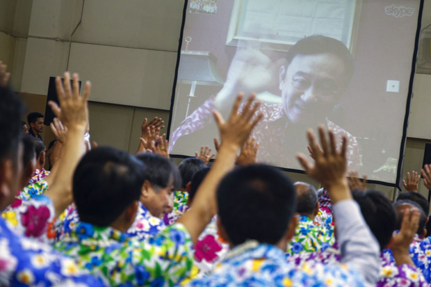 Các nghị sĩ đảng Puea Thai nghe cựu Thủ tướng Thaksin Shinawatra phát biểu tại trụ sở của đảng ở Bangkok.                   Ảnh: AFP