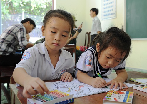   Two primary school pupils colouring a picture