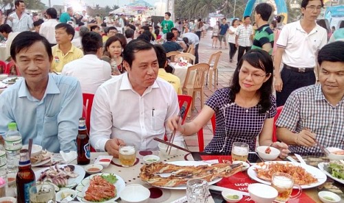 Huynh Duc Tho (2nd L), chairman of the Da Nang People's Committee, attends the seafood festival in the central city on May 1, 2016.