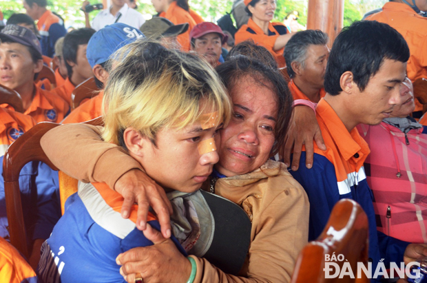 Bà Bùi Thị Luận, vợ thuyền trưởng Thành ôm con trai khóc nức nở khi được tàu cứu nạn đưa lên bờ