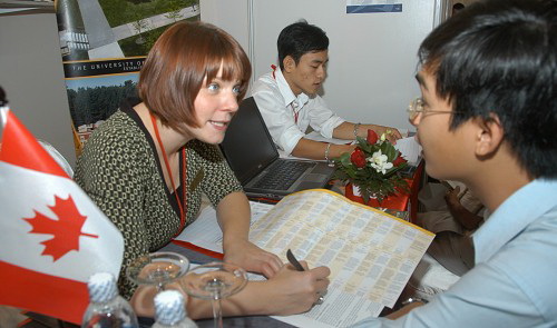 A Vietnamese student (right) learns about studying in Canada at an education fair in Ho Chi Minh City. Tuoi Tre