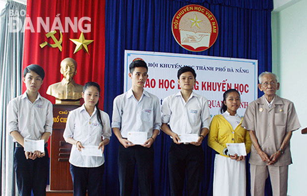 Ông Lâm Quang Minh tặng học bổng cho học sinh mồ côi nghèo.