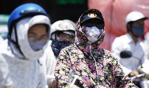 People are seen wearing protective clothes to cope with the scorching heat in Ha Noi