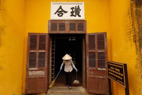 A woman wear a non la while cleaning the Museum of Folklore in Hoi An. Photo: Reuters