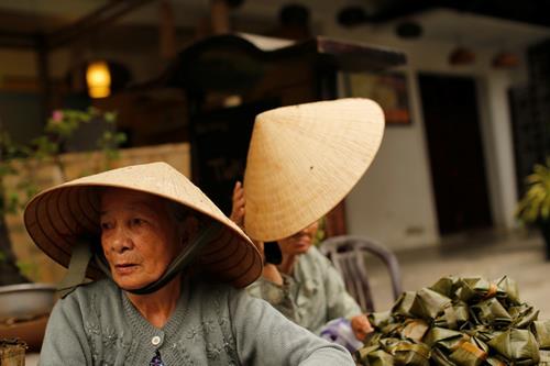 Women wearing traditional hats, known as non la, sit in a market in Hoi An, Vietnam April 5, 2016. Photo: Reuters