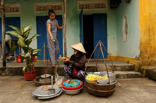 A woman wearing a traditional hat, known as a non la, sells food for breakfast in Hoi An, Vietnam April 5, 2016. Photo: Reuters