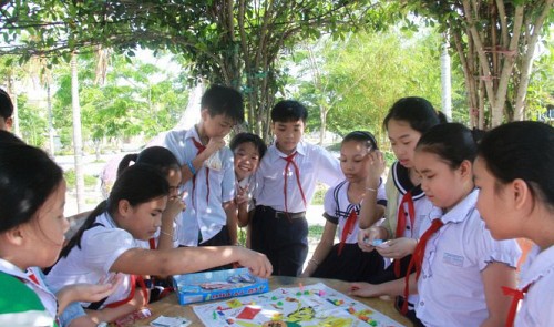 Students play a board game under the shade of trees at Le Ba Trinh Elementary School in Da Nang City. Tuoi Tre