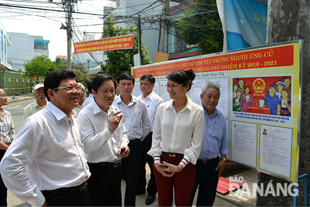 Đồng chí Võ Công Trí (bìa trái) kiểm tra địa điểm niêm yết danh sách ứng cử viên và khu vực bỏ phiếu trên địa bàn phường An Hải Bắc. Ảnh: Việt Dũng 