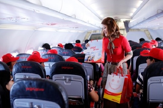 A Vietjet flight attendant delivers gifts to passengers. (Source: VNA)