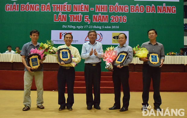 Phó Tổng biên tập Báo Đà Nẵng Lê Quang Á, Trưởng Ban tổ chức giải (giữa) tặng  hoa và Kỷ niệm chương cho đại diện các đơn vị tài trợ.