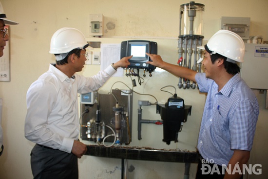 Secretary Anh (left) being shown clean water quality management equipment at the Cau Do water supply plant