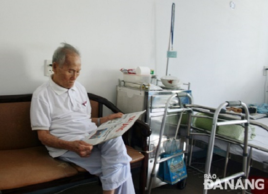 Mr Gia reading the Da Nang Newspaper