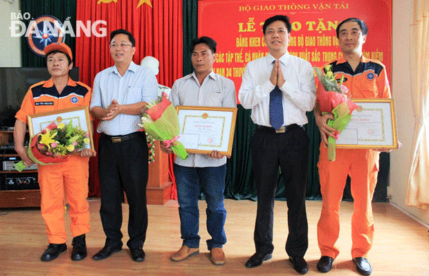 Thứ trưởng Bộ GTVT Nguyễn Ngọc Đông (thứ 2 từ phải qua) tặng bằng khen cho các tập thể, cá nhân có thành tích xuất sắc trong công tác ứng cứu 34 ngư dân Quảng Nam trên tàu cá bị tàu lạ đâm chìm.