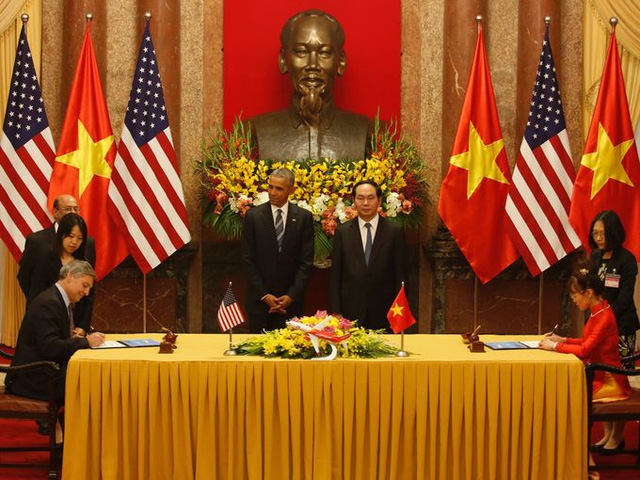 Trước sự chứng kiến của Chủ tịch nước Trần Đại Quang và Tổng thống Mỹ Barack Obama, Chủ tịch kiêm giám đốc điều hành Tập đoàn Boeing (trái) và CEO của Vietjet Nguyễn Thị Phương Thảo ký thỏa thuận. Theo đó, Vietjet sẽ mua 100 máy bay Boeing. (Ảnh: AFP)