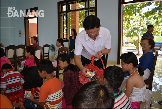 Phó Bí thư Thường trực Thành ủy Võ Công Trí tặng quà cho trẻ em Làng SOS nhân Ngày Quốc tế Thiếu nhi 1-6. Ảnh: TRỌNG HÙNG