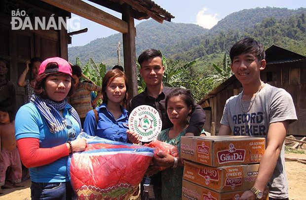 Kim Thoa (bìa trái) cùng các tình nguyện viên trao quà của các mạnh thường quân cho đồng bào dân tộc nghèo ở Trà Leng.