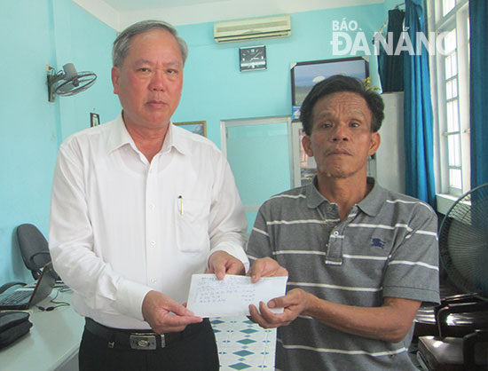  Acting Editor-in-Chief Truong Cong Dinh handing the donations to Mr Kha