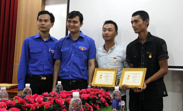 Anh Bùi Quang Huy, Trưởng ban tổ chức Trung ương Đoàn (thứ 2, từ trái qua) trao huy hiệu Tuổi trẻ dũng cảm chô Lê Văn Hoa và Mai Viết Dụng đã dũng cảm cứu người trong vụ lật tàu trên sông Hàn đêm 4-6.