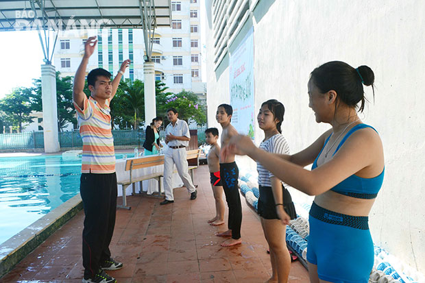 Dạy bơi cho các em tại bể bơi Trường THPT chuyên Lê Quý Đôn.Ảnh: PHƯƠNG TRÀ