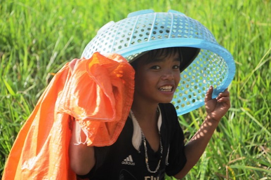 A youngster poses with a bag and a basket – his main fishing kit. Photo: Tuoi Tre
